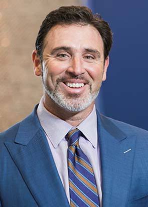 man with dental implants in Medford wearing a suit and smiling