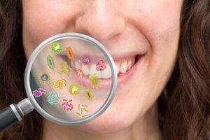 Magnifying glass being held up to a woman's smile to reveal gum disease